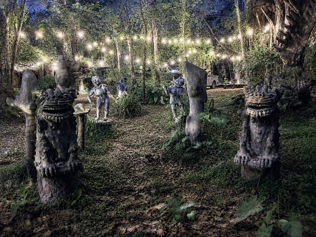Warlock House Statuary illuminated at night beneath cafe lights in Wesley Chapel